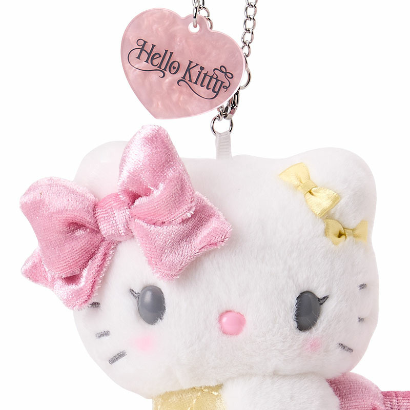 顔とタグのアップ。小さな黄色いリボン、チーク、Hello Kittyの文字が入ったハート形タグを確認できます。 画像:サンリオ公式楽天店。