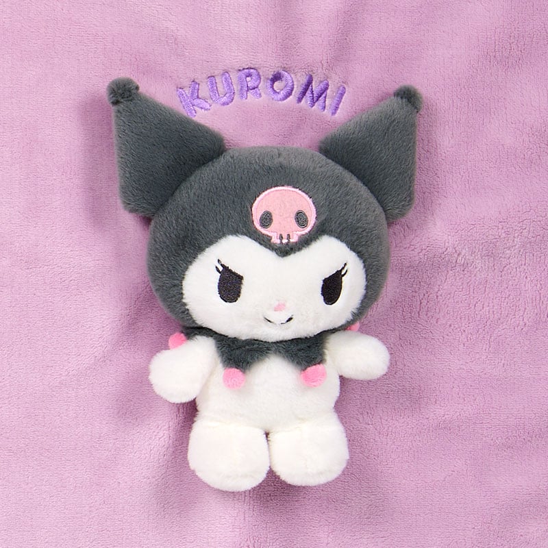 マスコットの接写。黒い頭巾とピンクのドクロ、手足、KUROMIの刺繍が見えます。 画像：サンリオ公式本店。